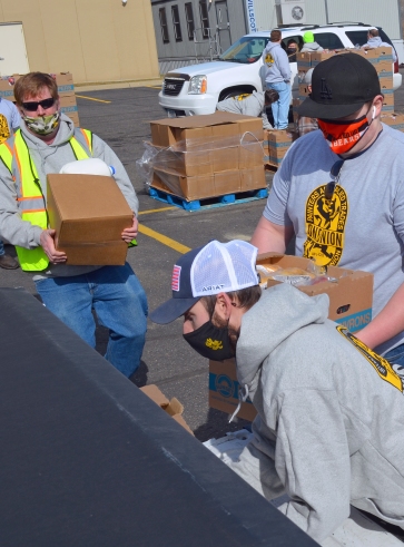 Volunteers with District Council 82 of the International Union of Painters and Allied Trades load food into a pickup during a giveaway at their union hall in Little Canada.